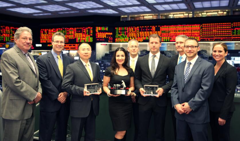 Gruppenfoto bei der Trading-Weltmeisterschaft vor den Börsenanzeigen